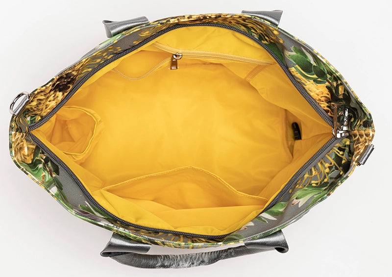 The interior of the Helena large canvas tote bag is lined with yellow waterproof fabric and shows multiple pockets.