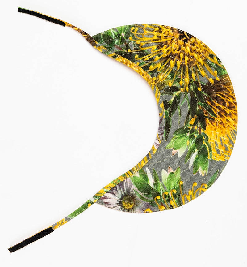 The Helena sun visor hat from Wild Things Lifestyle has yellow pincushion flowers on a grey background.