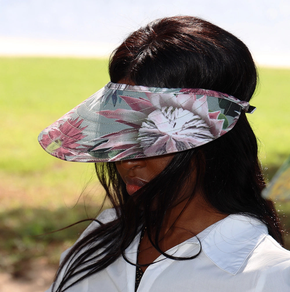 Dark haired lady wearing the Bernadette wide-brimmed sun visor hat which is completely shading her face.