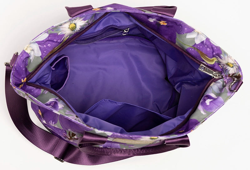 The interior of the Phoebe canvas tote bag has multiple pockets including a zip pocket and a bottle pocket in the purple lining.