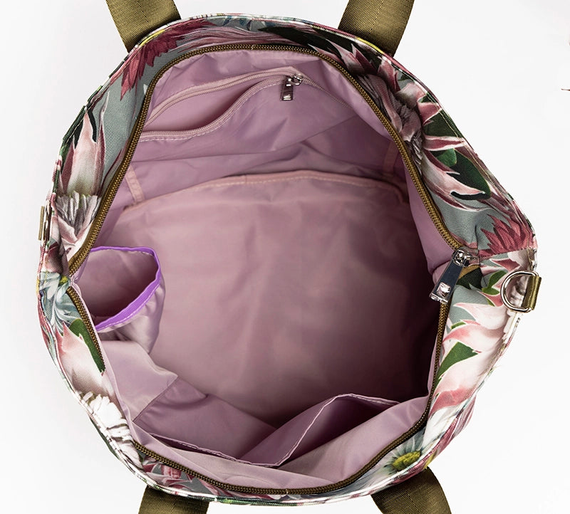 Top view of an open Bernadette large canvas tote bag showing pink lining with pockets and zips.