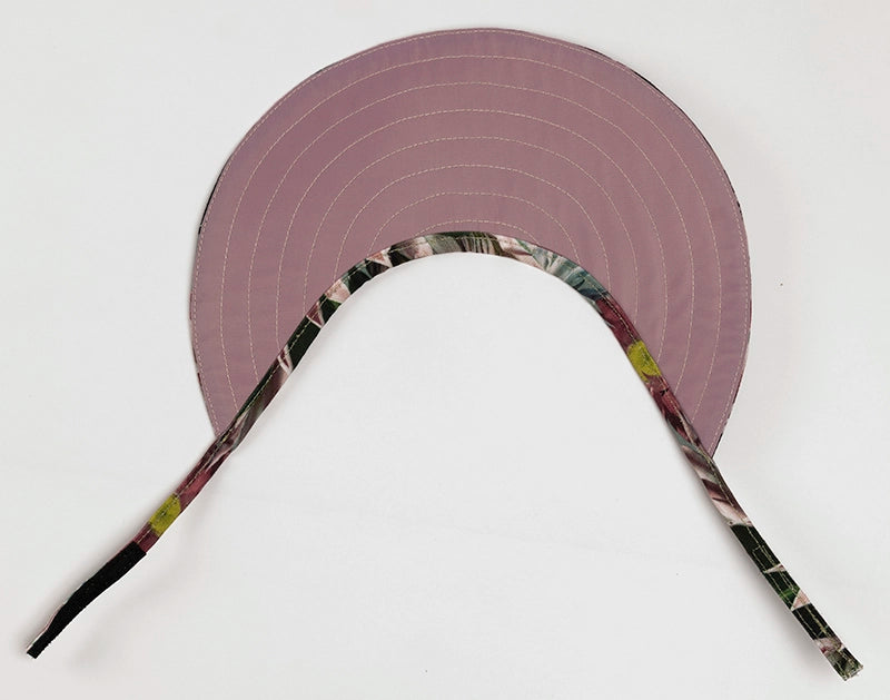 The pink lining of the reversible Protea Sun Visor Hat.