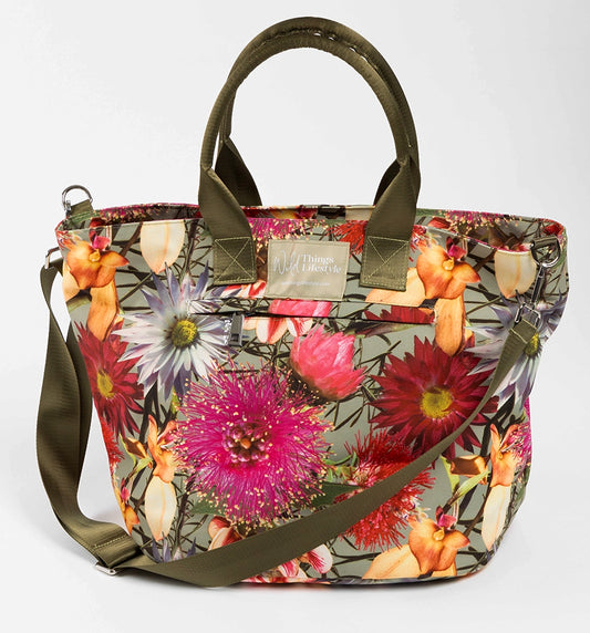 Florence is a bright floral large canvas tote bag showing the Wild Things Lifestyle label. the outside zip pocket and the green cross-body strap.